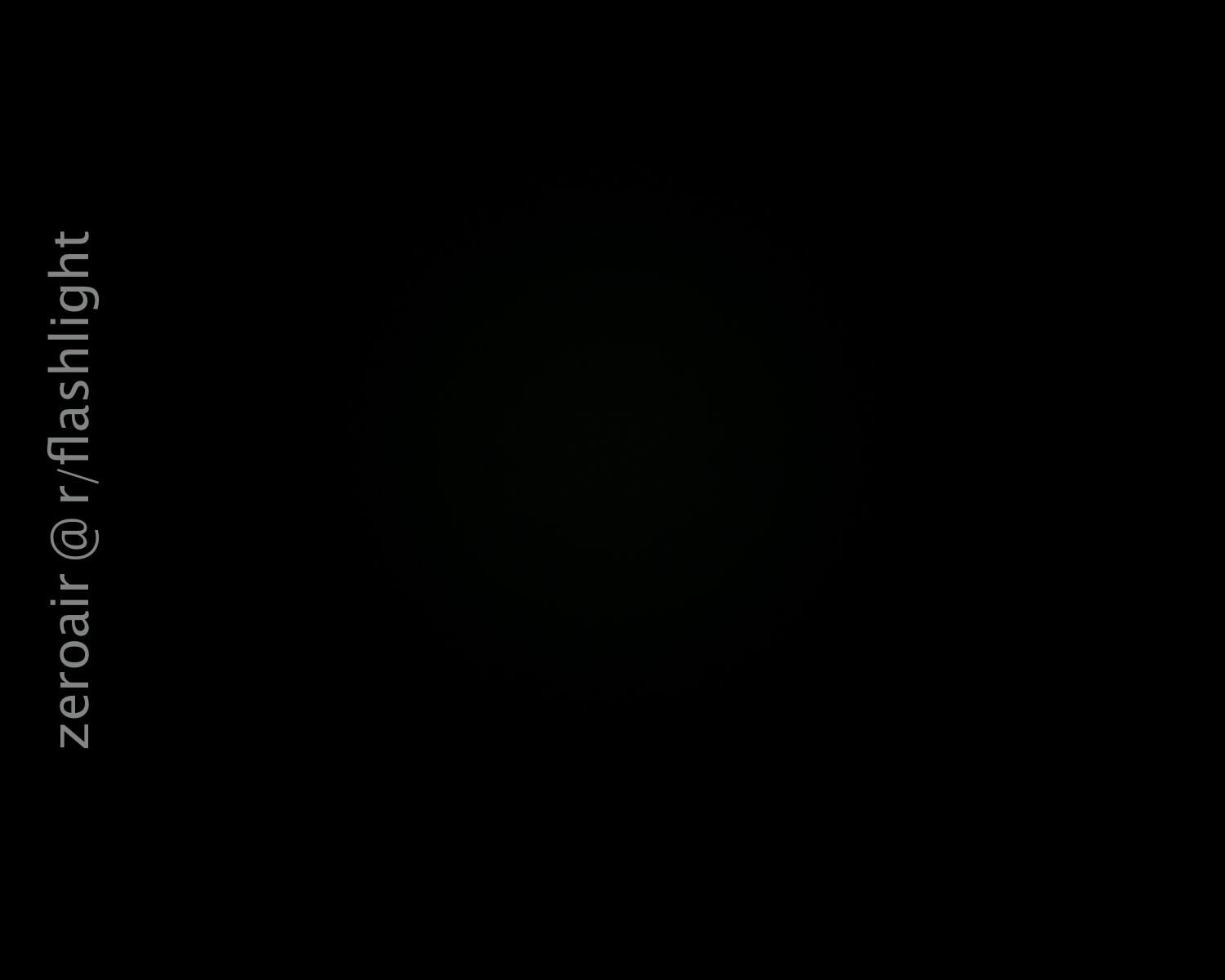 An almost completely black image with very faint light visible in the center. The text zeroair @ r/flashlight is written vertically along the left side.