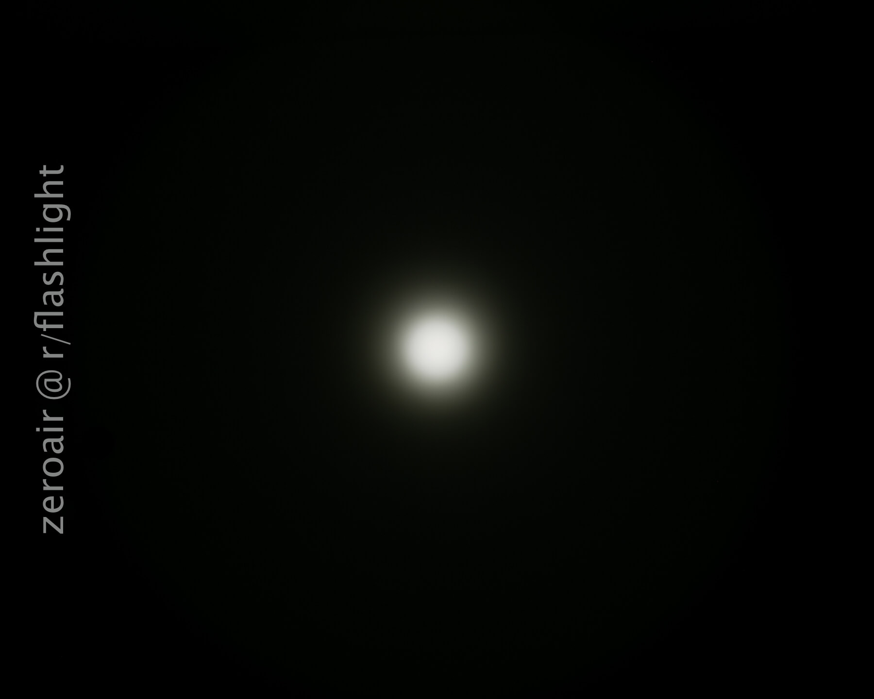 A white circular light is centered on a dark background, creating a halo effect. Text along the left side reads zeroair @r/flashlight.