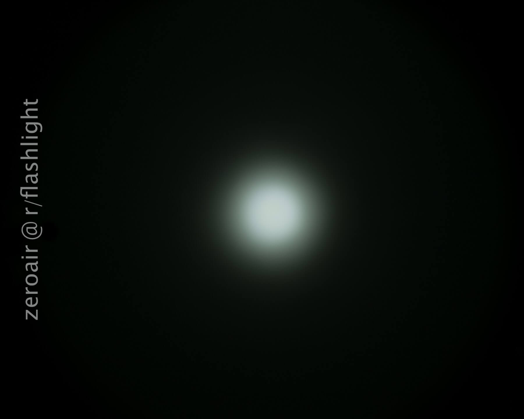 A bright white circular light is centered against a dark background. The light fades gradually into darkness. The text “zeroair @ r/flashlight” appears vertically along the left side.