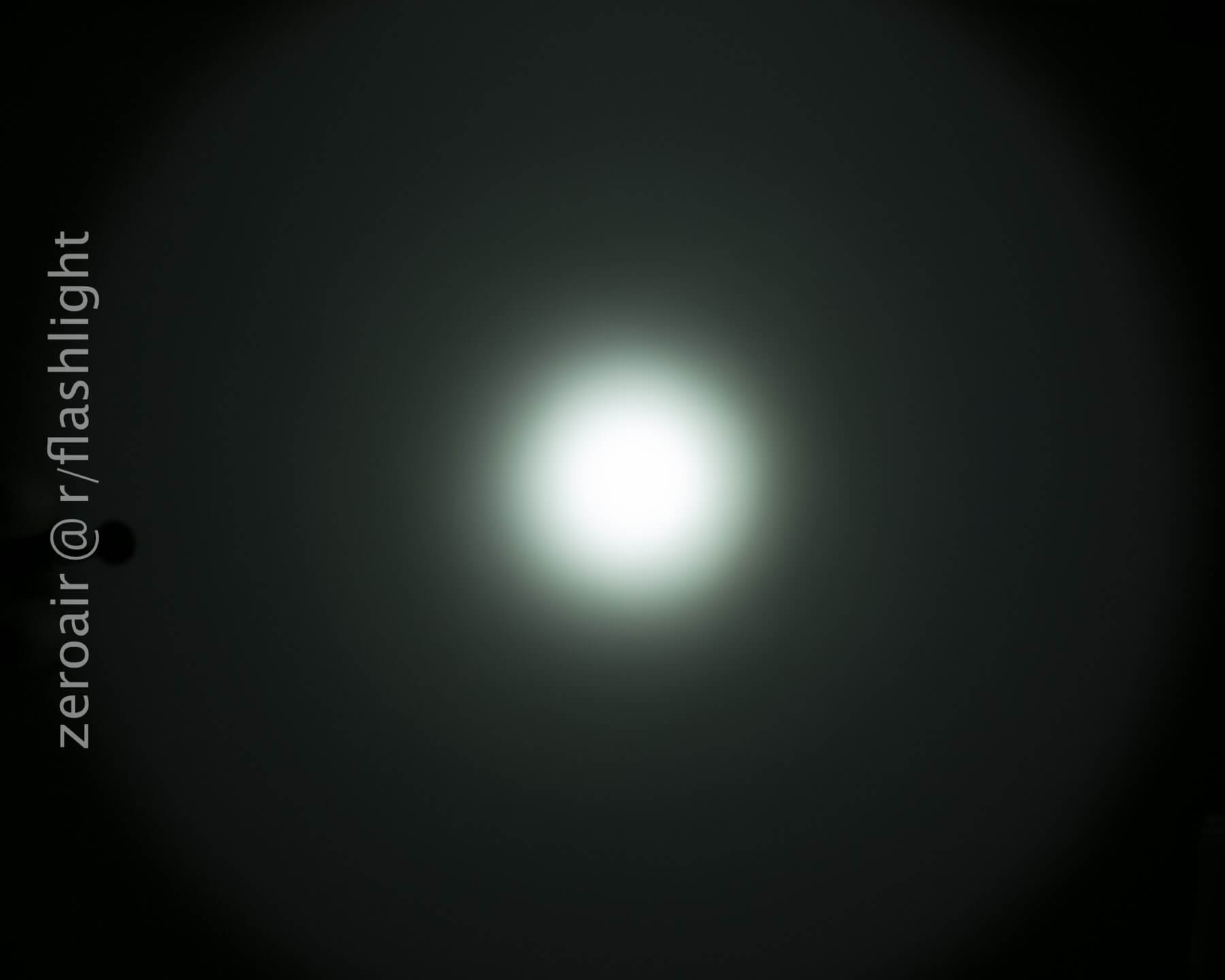 A bright white circular light is centered against a dark background, creating a gradient halo effect. The text zeroair @ r/flashlight appears vertically along the left side of the image.