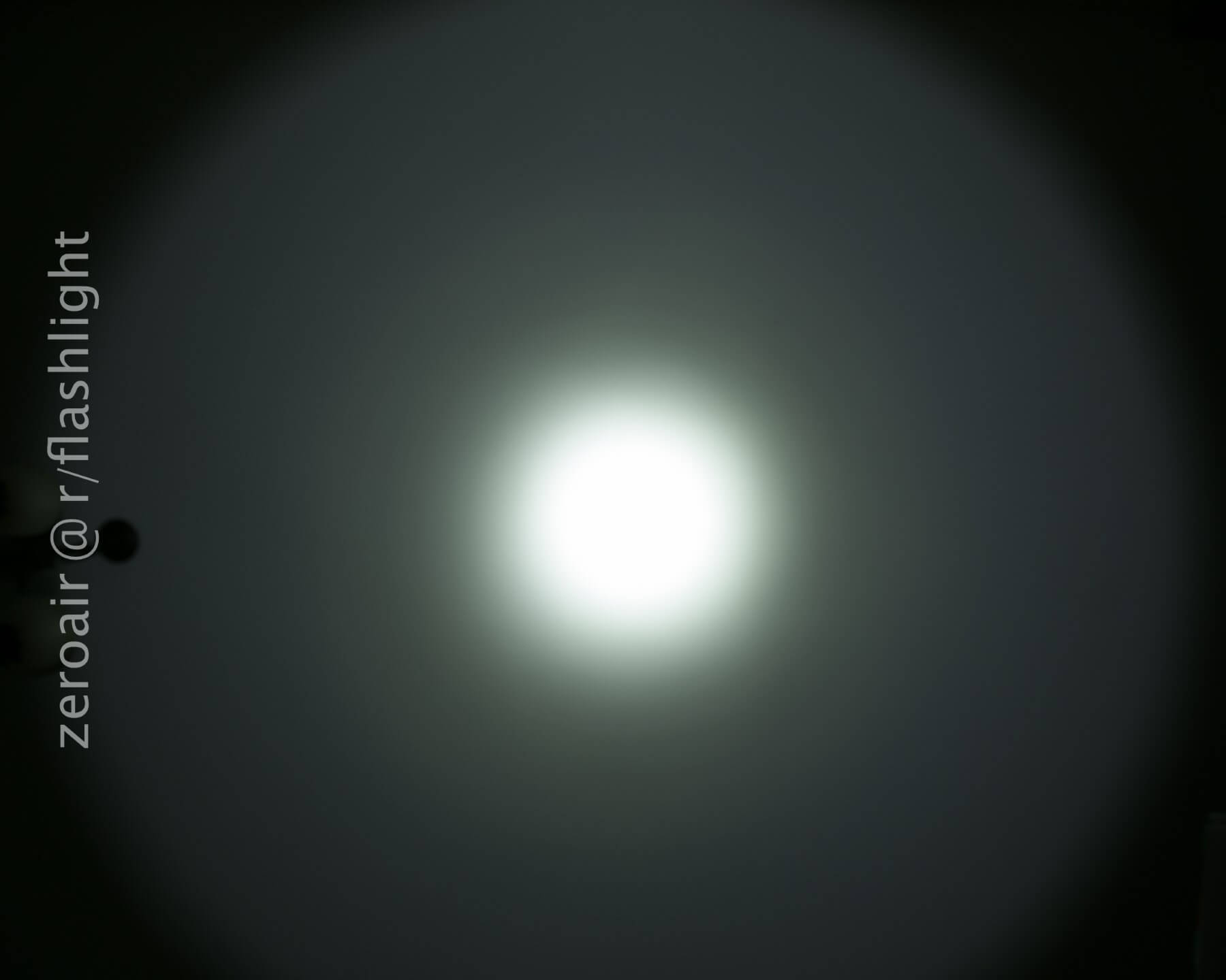 A bright white circular light beam is centered against a dark background, creating a halo effect. The text zeroair @ r/flashlight appears vertically on the left side of the image.