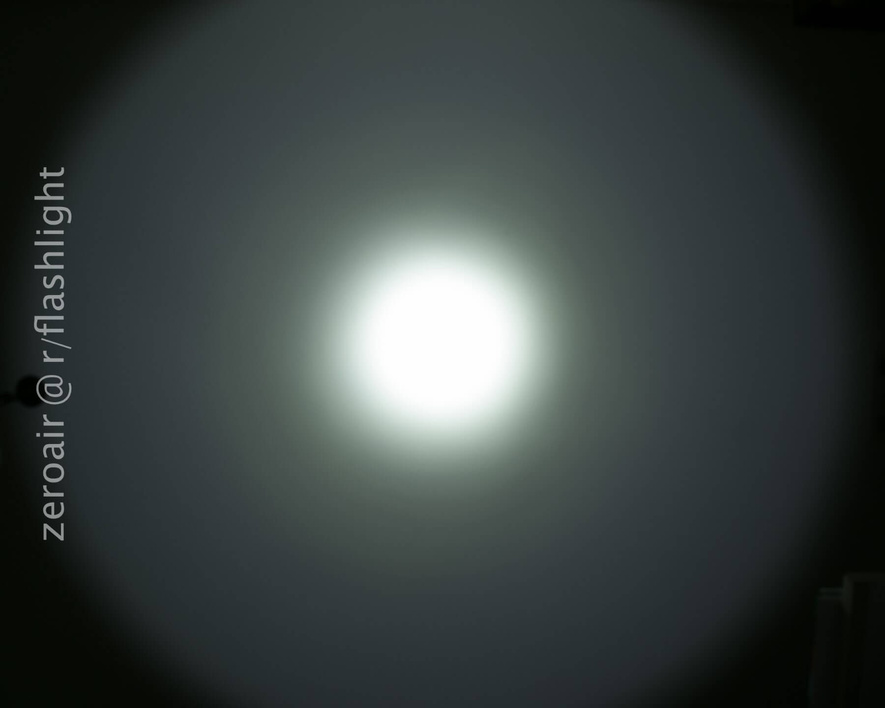 A bright white circle of light with a gradual fading halo effect on a dark background. The text zeroair @ r/flashlight appears vertically along the left side.