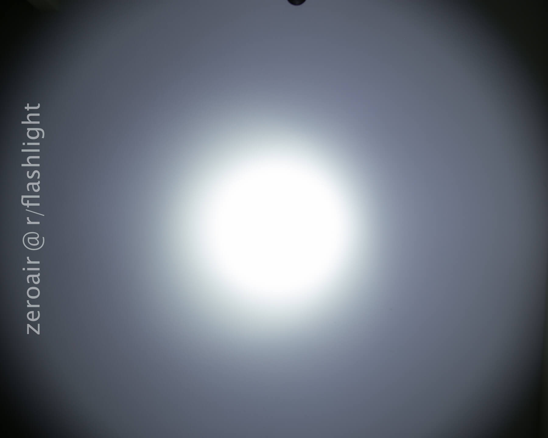 A bright white circular light appears in the center of a dark background, creating a halo effect. The text zeroair @ r/flashlight is vertically aligned on the left side of the image.