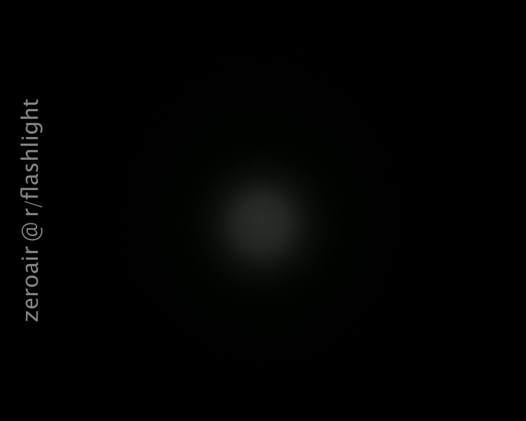 A faint, blurry circular light is centered against a black background. The text zeroair @ r/flashlight appears vertically along the left side.