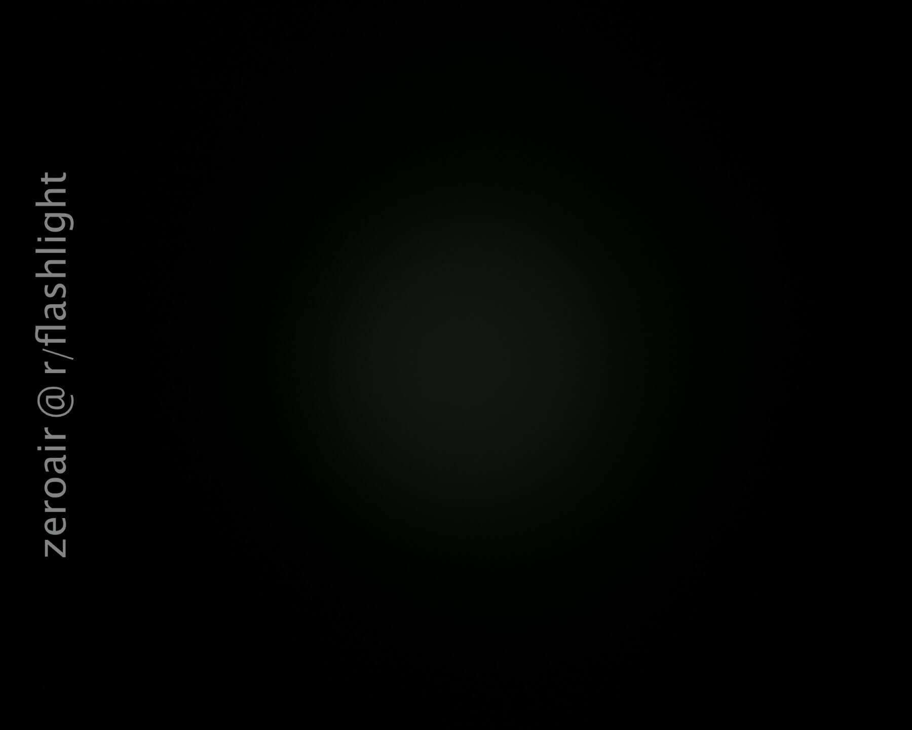 A faint circular glow is visible in the center of a mostly black image. The text zeroair @ r/flashlight is vertically aligned on the left side.