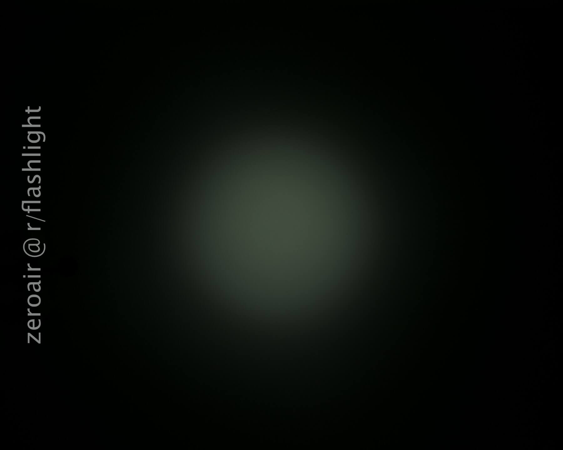 A dim, circular beam of light is shown against a black background. The text zeroair @ r/flashlight is vertically aligned on the left side of the image.
