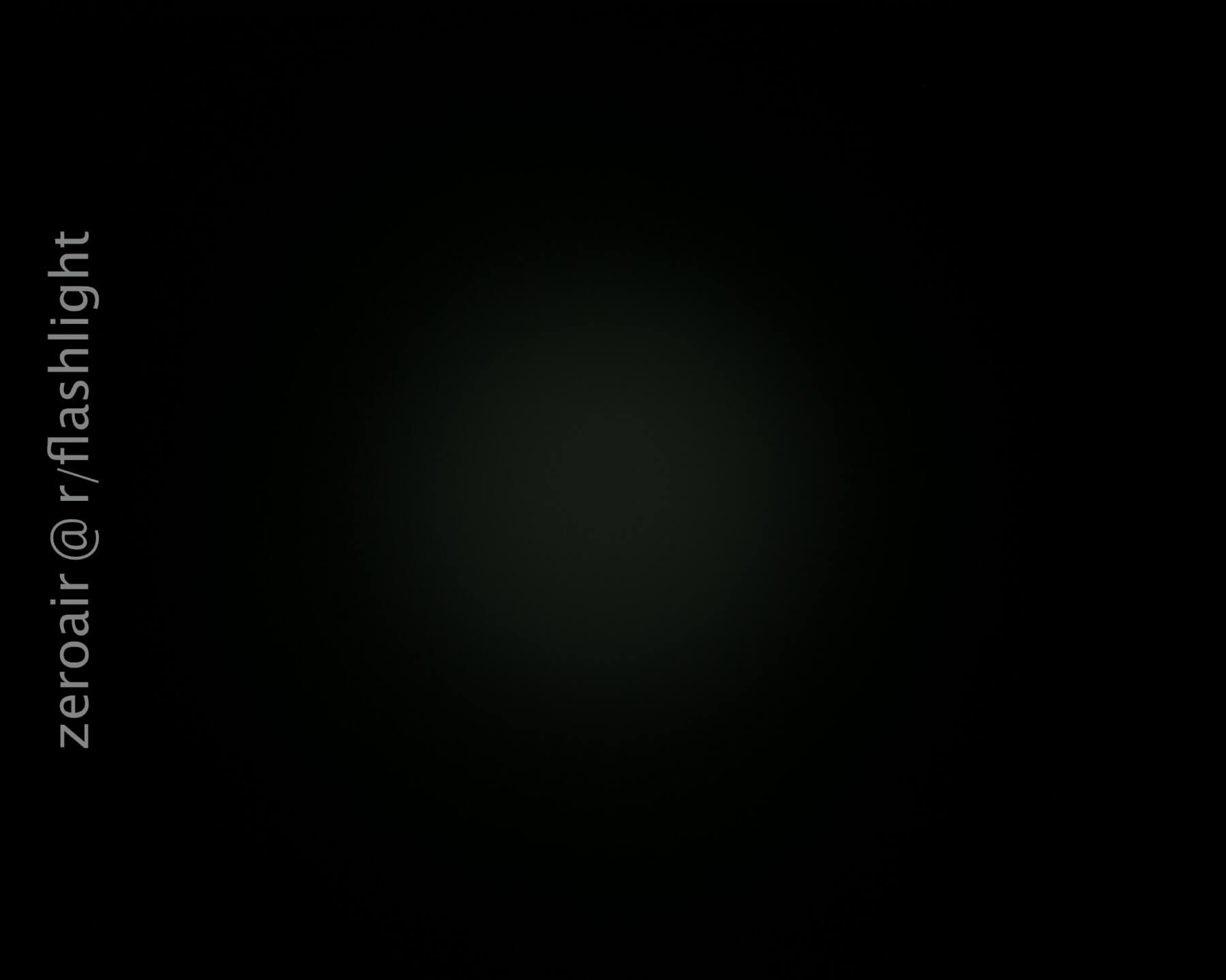 A dim, circular light is visible in the center of a dark background. The text zeroair @ r/flashlight appears vertically along the left side of the image.