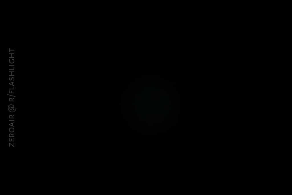 A mostly black image with a faint circular area of dim light in the center; the text ZEROAIR @ R/FLASHLIGHT appears vertically along the left edge.