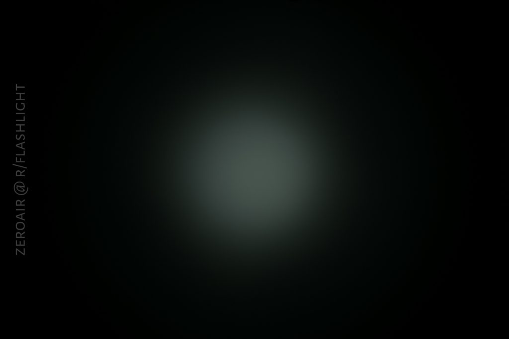 A dark image with a faint, circular, diffused white light in the center. The background is black. Vertical text on the left side reads “ZEROAIR @ R/FLASHLIGHT.”