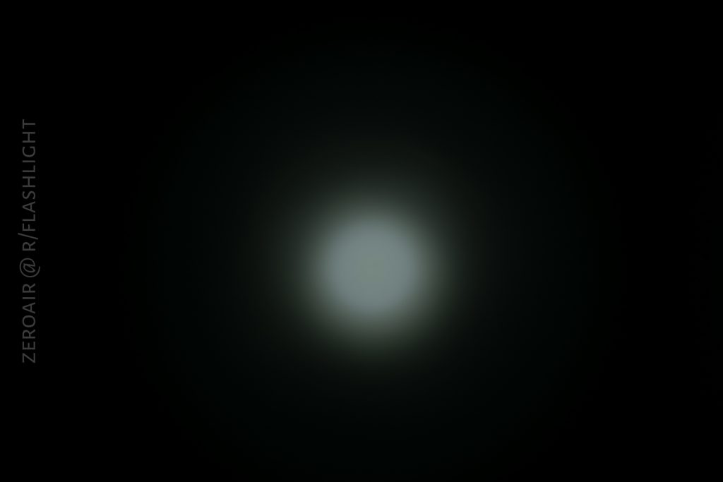 A bright circular white light source in the center of a dark background, creating a soft halo effect. Text on the left side reads ZEROAIR @ R/FLASHLIGHT.