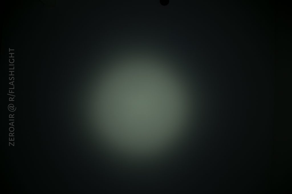 A circular, soft white beam of light is projected onto a dark background. The text ZEROAIR @ R/FLASHLIGHT appears vertically along the left side.