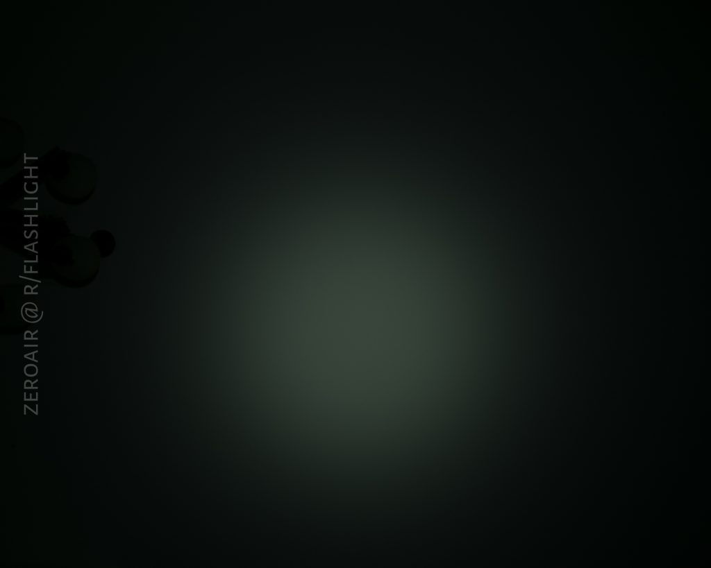 A dim, circular beam of light is visible in the center of a dark background. On the left edge, faint outlines of light bulbs can be seen. The text ZEROAIR @ R/FLASHLIGHT appears vertically along the left side.