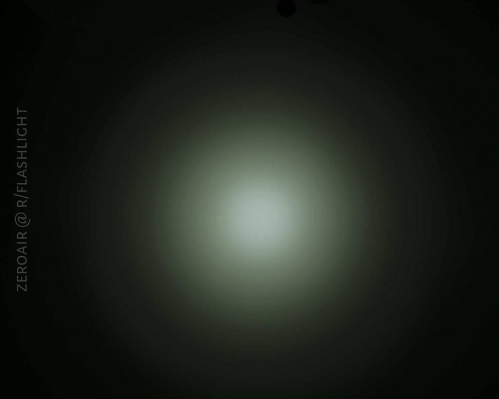A circular, white beam of light with a soft greenish tint gradually fades into darkness. The words ZEROAIR @ R/FLASHLIGHT are written vertically on the left side.
