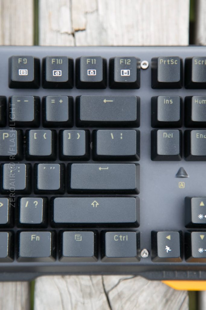 Close-up of the top right section of a computer keyboard showing the F9 to F12 keys, Insert, Delete, arrow keys, Fn, and Ctrl keys. The keys have yellowish symbols and the keyboard has a black frame.