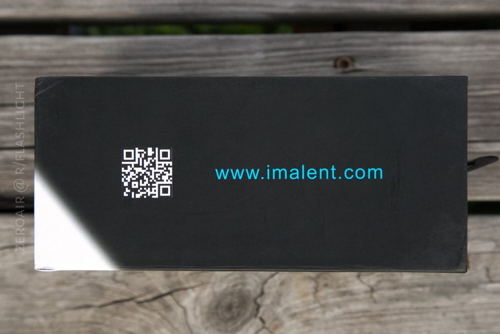 A black rectangular box with a QR code and the website address www.imalent.com printed in blue text on the side, placed on a weathered wooden surface.
