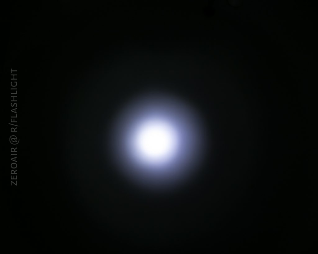 A bright white circular light is centered against a dark background with a faint halo. The left side has the text ZEROAIR @ R/FLASHLIGHT in a vertical orientation.