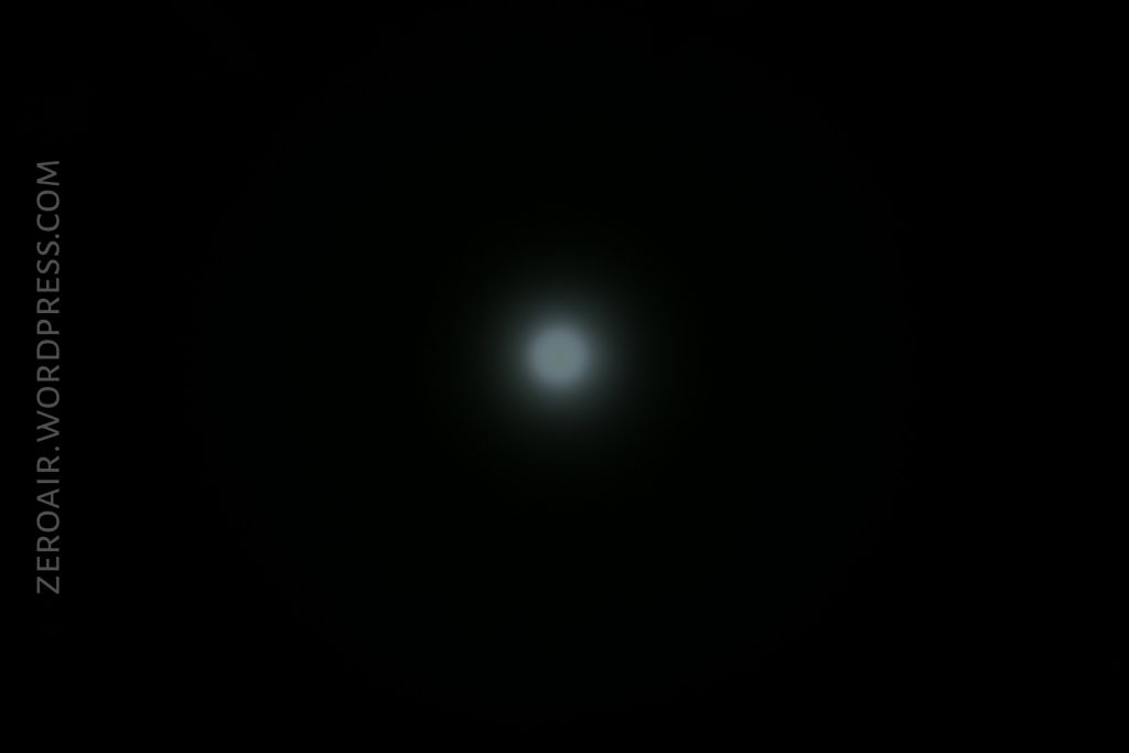 A small, bright white light is centered against a black background, surrounded by a faint, hazy glow. The text ZEROAIR.WORDPRESS.COM is written vertically along the left edge.