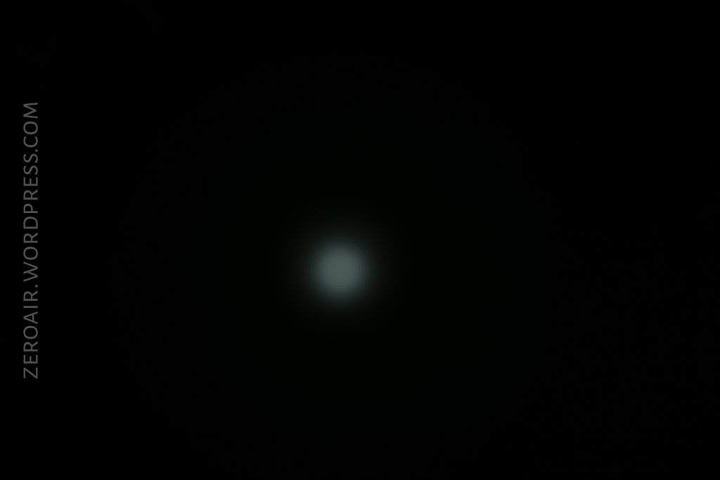 A dim, circular white light appears in the center of a black background. The text ZEROAIR.WORDPRESS.COM is vertically aligned along the left side.