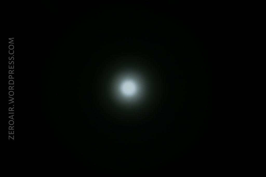 A bright, circular white light is centered against a dark black background. The light has a soft, glowing halo around it. The text ZEROAIR.WORDPRESS.COM appears vertically along the left side.