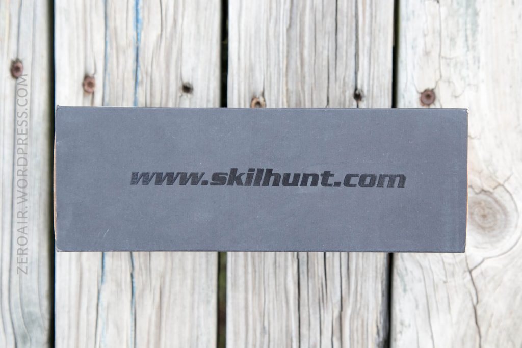 A rectangular black box with the text www.skilhunt.com printed in gray on the top, placed on a weathered wooden surface. The watermark ZEROAIR.WORDPRESS.COM is visible on the left edge.
