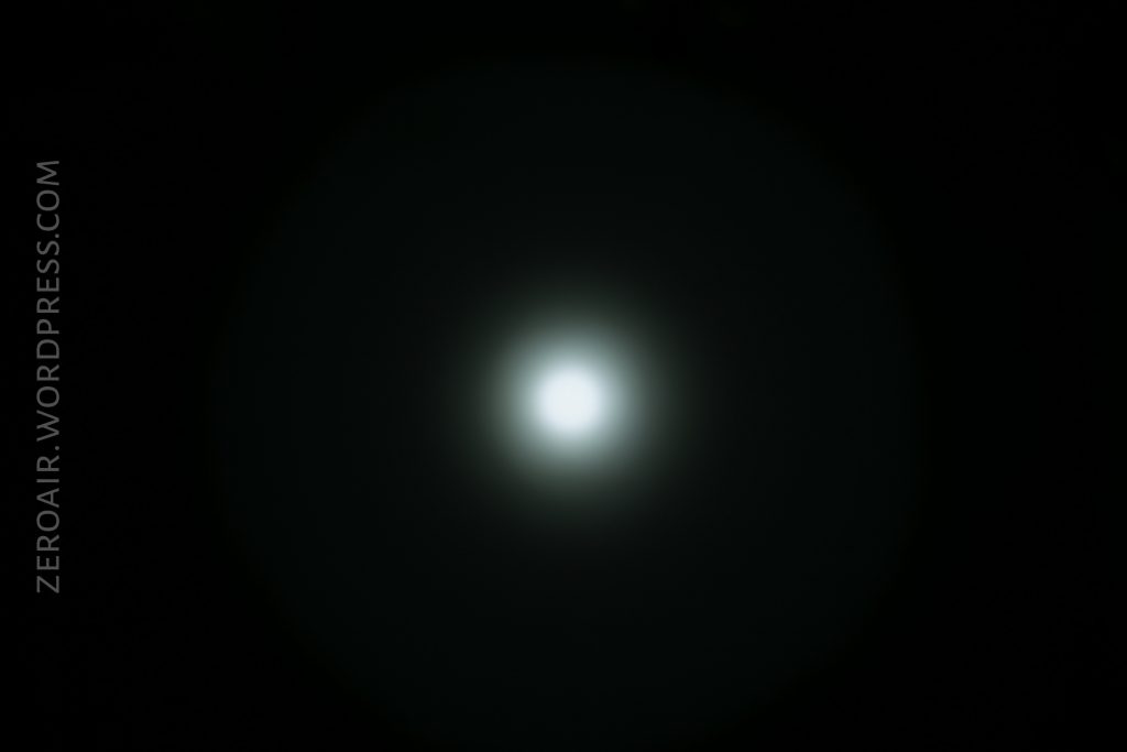 A circular white light glows at the center of a dark background, fading outward in a gradient. The text ZEROAIR.WORDPRESS.COM appears vertically along the left side.