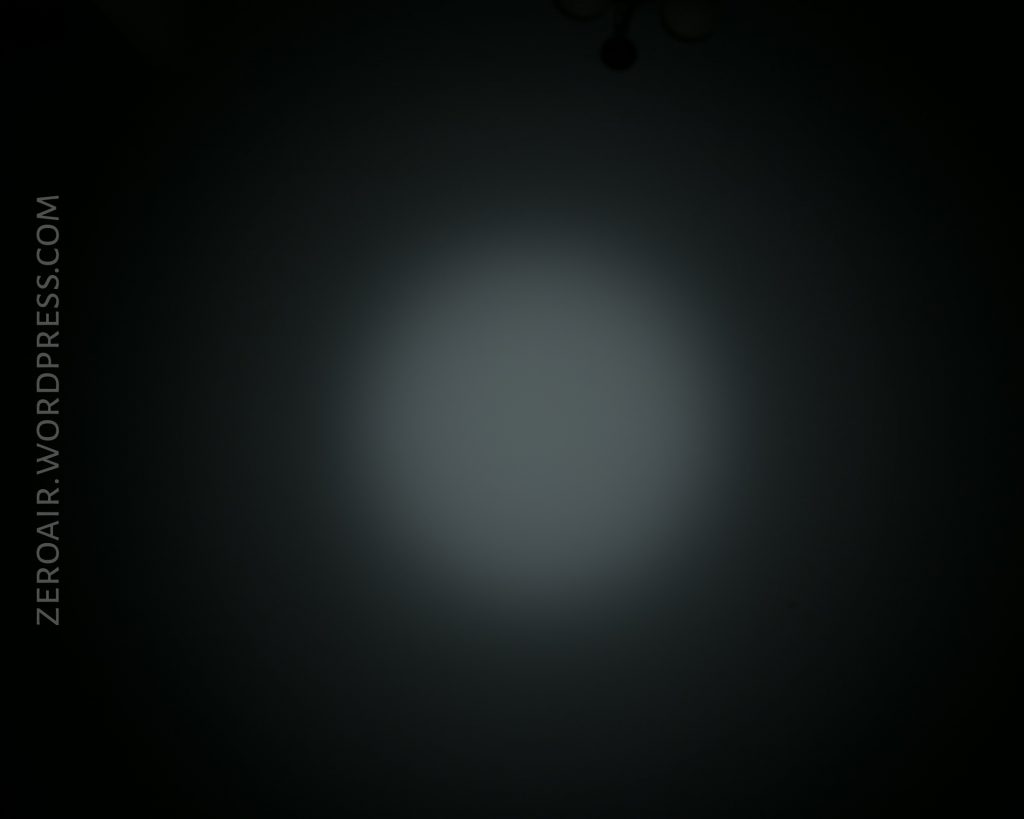 A circular, white beam of light is projected onto a dark surface with the text “ZEROAIR.WORDPRESS.COM” vertically along the left side of the image.