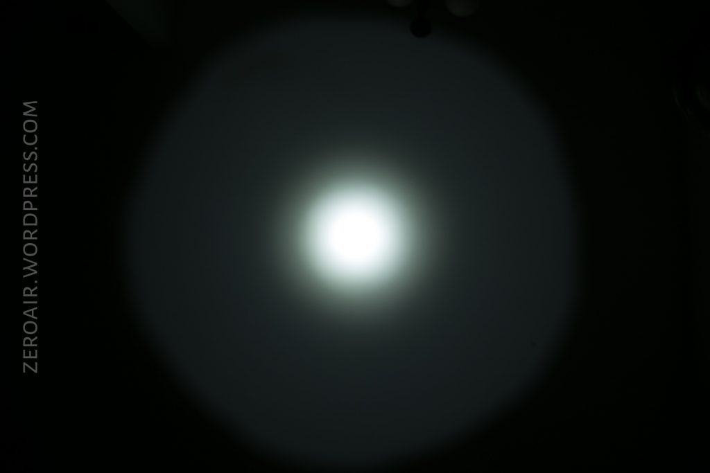 A bright white circular light shines in the center of a dark background, creating a halo effect. The text ZEROAIR.WORDPRESS.COM appears vertically along the left side of the image.