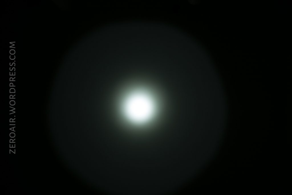 A bright white circular light is centered on a dark background, with a soft, diffuse halo around it. The text ZEROAIR.WORDPRESS.COM appears vertically on the left side.