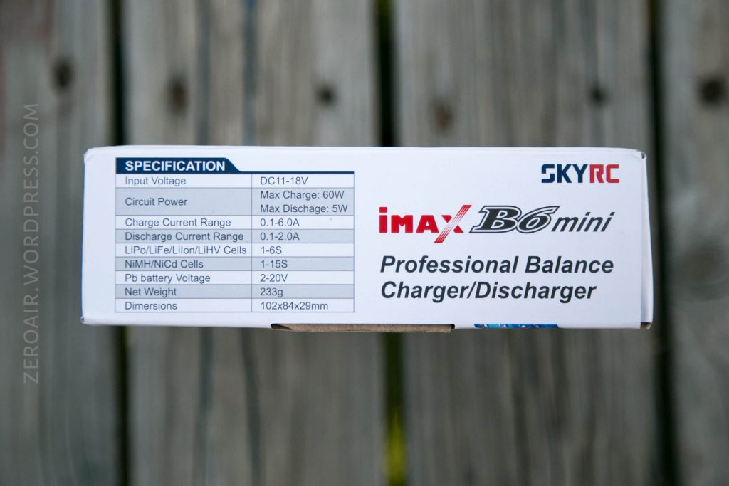 A close-up of the side of a SKYRC iMAX B6 mini Professional Balance Charger/Discharger box, showing the specifications table including input voltage, current range, battery types, and dimensions.