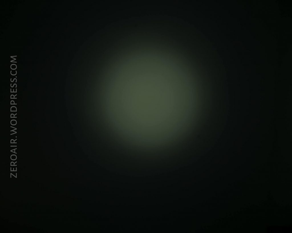 A dim, round light spot is visible in the center of a dark background. The gradient fades smoothly from the light center to nearly black edges. The text ZEROAIR.WORDPRESS.COM runs vertically on the left side.