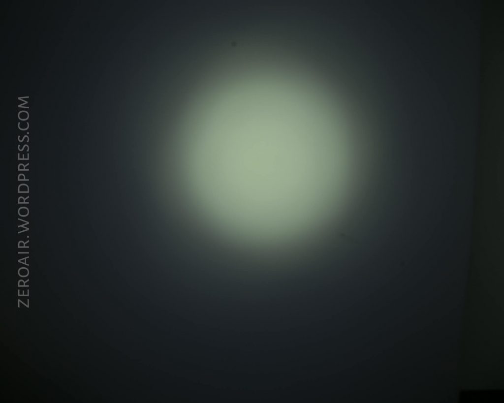 A circular beam of light is projected onto a dark surface, with ZEROAIR.WORDPRESS.COM written vertically on the left side of the image.