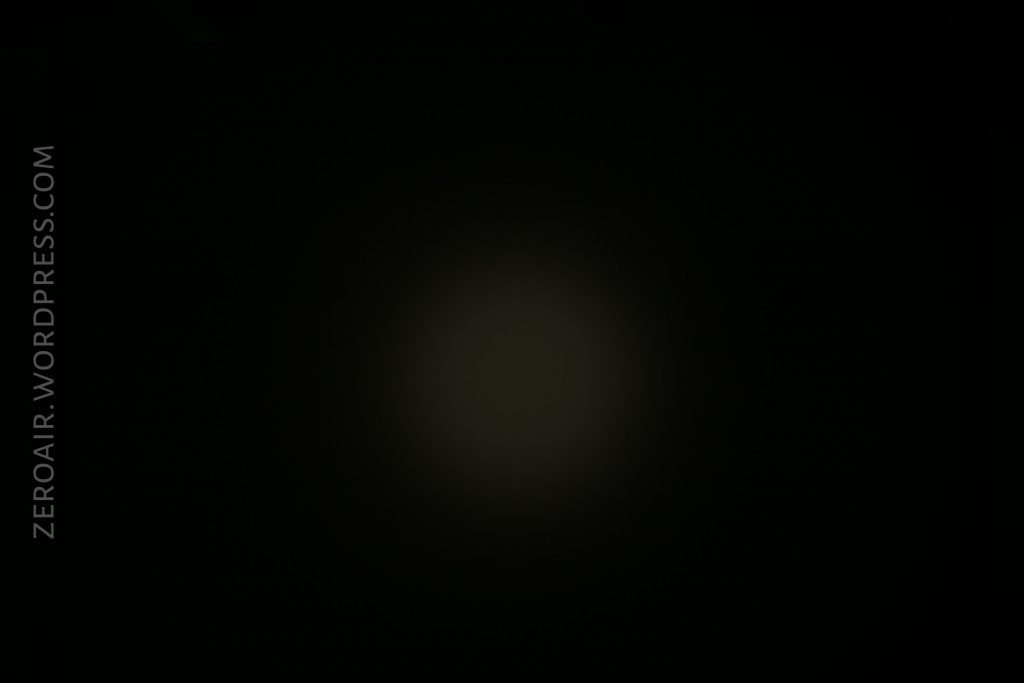 A dim circular spot of light appears in the center of a mostly black background. The text ZEROAIR.WORDPRESS.COM runs vertically along the left side of the image.