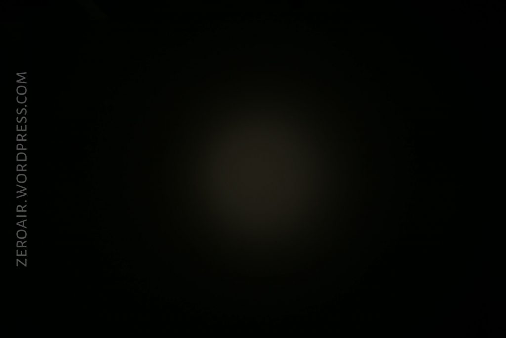 A dark image with a faint, dim circle of light in the center. The background is mostly black. The text ZEROAIR.WORDPRESS.COM appears vertically along the left edge.