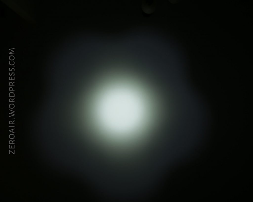 A white circular light beam shines on a dark background, creating a soft, diffused glow with a gradient edge. The text ZEROAIR.WORDPRESS.COM appears vertically along the left side.