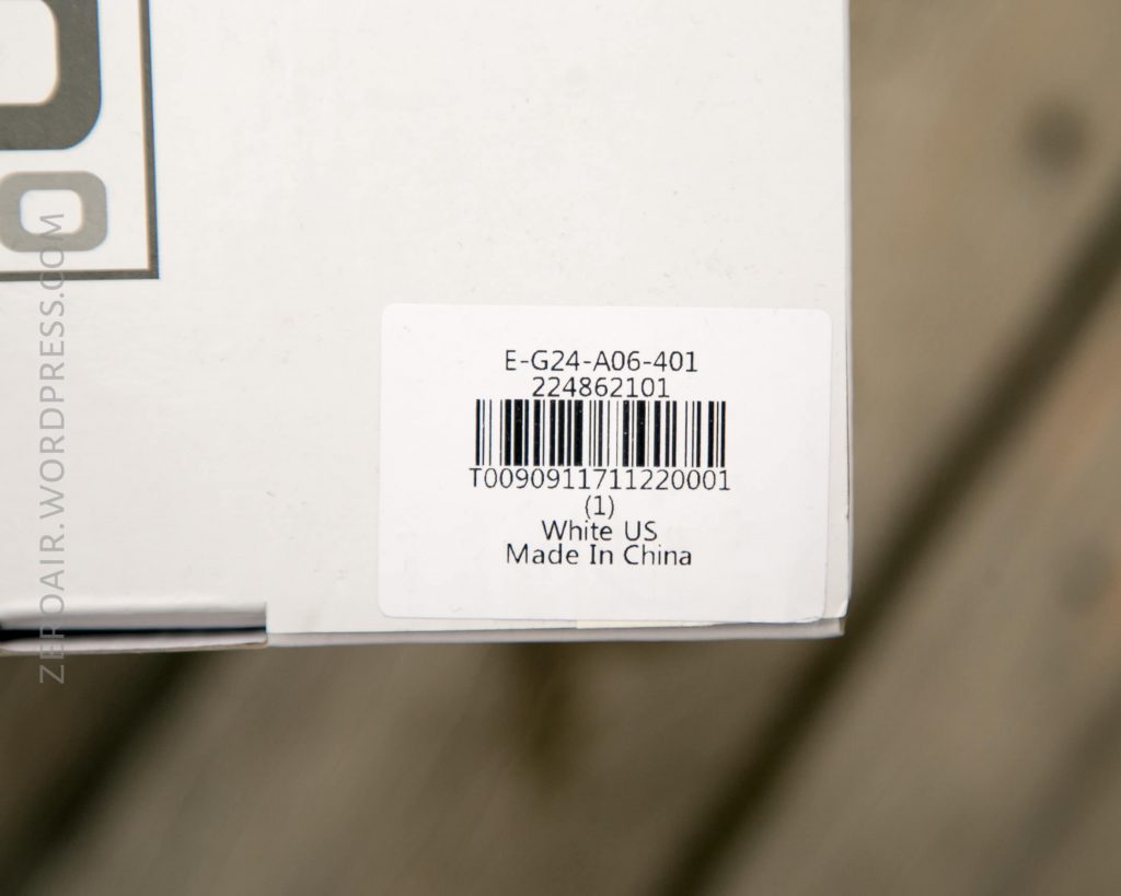 A close-up of a white barcode label on a cardboard box. The label displays a barcode, alphanumeric codes, “White US,” and “Made In China.” A partial website watermark is visible along the left side.