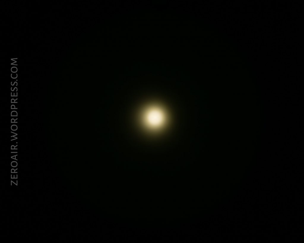 A single bright yellowish-white light glows in the center of a dark background. The words ZEROAIR.WORDPRESS.COM appear vertically along the left side of the image.