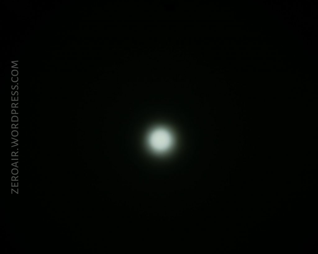A bright white circle of light is centered against a black background. The light has a faint, hazy glow around it. The text ZEROAIR.WORDPRESS.COM appears vertically on the left side.