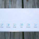 A white box displays six blue icons with labels: Charge, Discharge, Storage, Cycle, Activation, and Analysis. The background is wood. ZEROAIR.WORDPRESS.COM is written vertically on the left side.