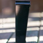 A black rectangular object stands upright on a weathered wooden surface with sunlight casting shadows. The background is out of focus. The text ZEROLIR.WORDPRESS.COM is faintly visible on the left side.