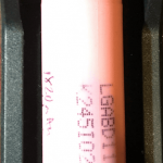 A pink cylindrical battery is placed in a LiitoKala charger, which displays a charging current of 0.57 amps on its digital screen. The charger has multiple mode indicators below the display.