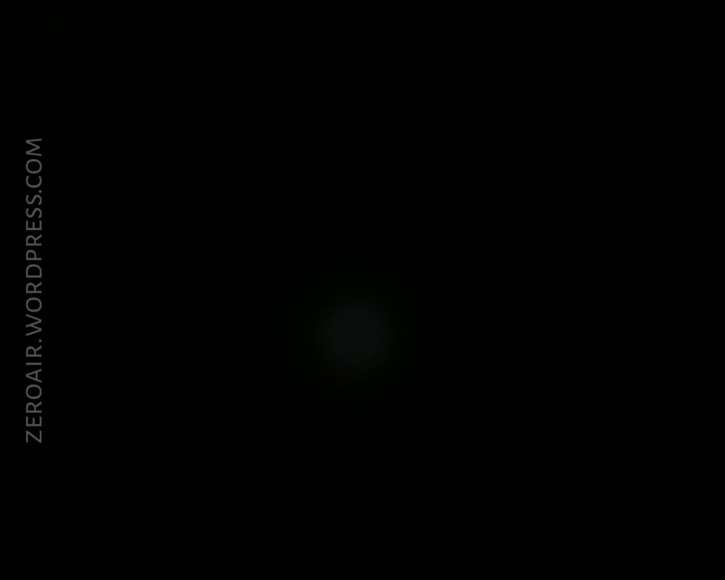 A nearly black image with a faint, barely visible spot in the center. ZEROAIR.WORDPRESS.COM is written vertically along the left side.