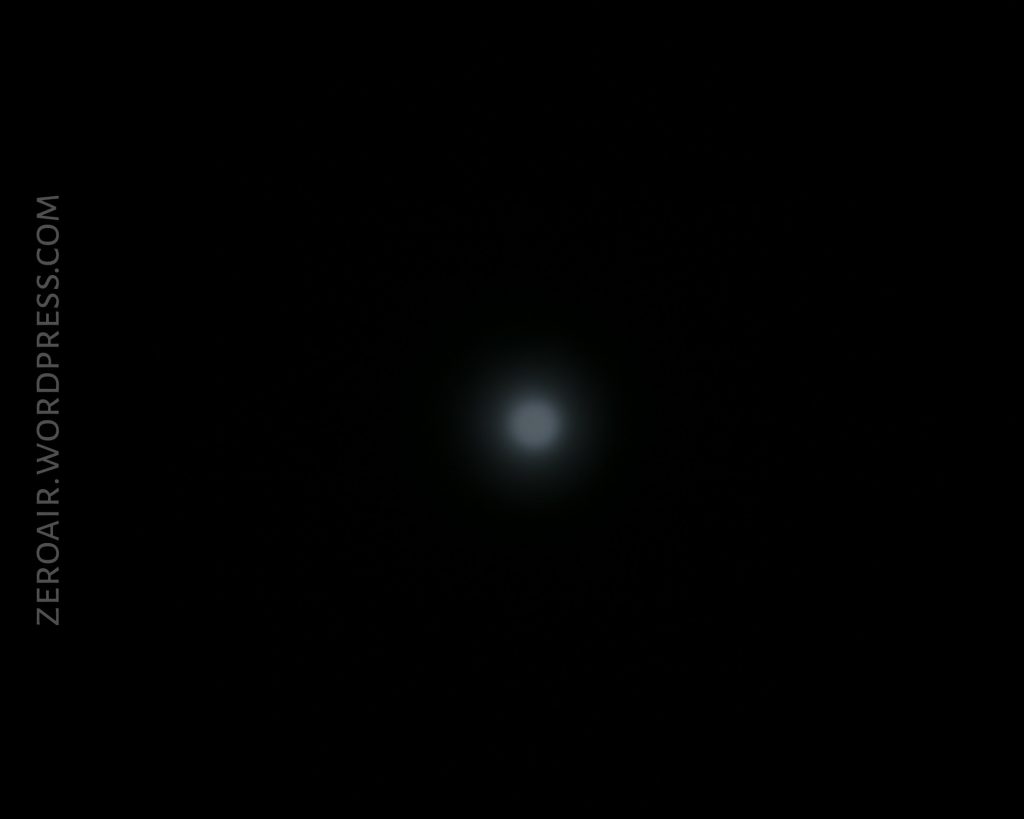 A small, white circular light appears in the center of a black background. The text ZEROAIR.WORDPRESS.COM is vertically aligned on the left side.