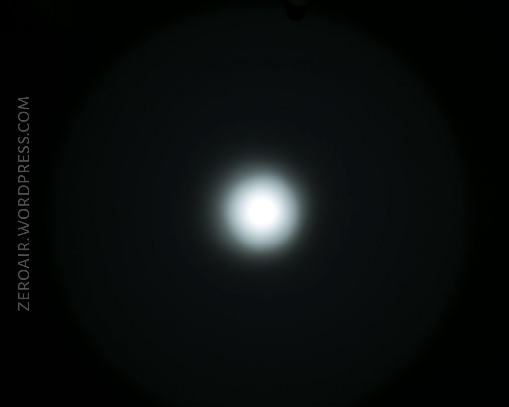 A bright white circle of light surrounded by a dark gradient, appearing as a spotlight or beam pattern, centered on a black background. The text “ZEROAIR.WORDPRESS.COM” is vertically aligned on the left side.