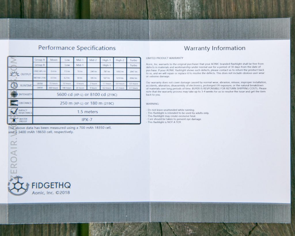 A close-up of a product manual page showing performance specifications and warranty information for a flashlight, including output, battery life, distance, water resistance, and company details from FIDGETHQ Aonic.