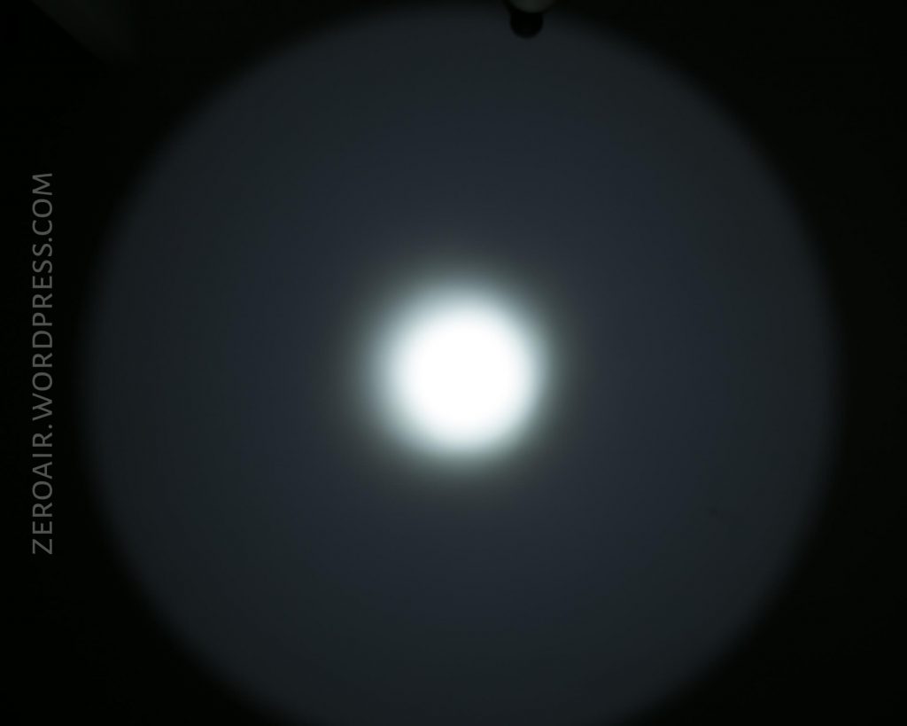 A bright white circle of light is centered against a dark background with a visible gradient. The text ZEROAIR.WORDPRESS.COM is written vertically along the left side of the image.