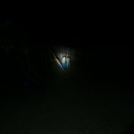 A dark backyard at night is illuminated by a flashlight, highlighting a blue and yellow plastic play structure near a wooden fence. The rest of the yard is barely visible. The text ZEROAIR.WORDPRESS.COM is on the left side.