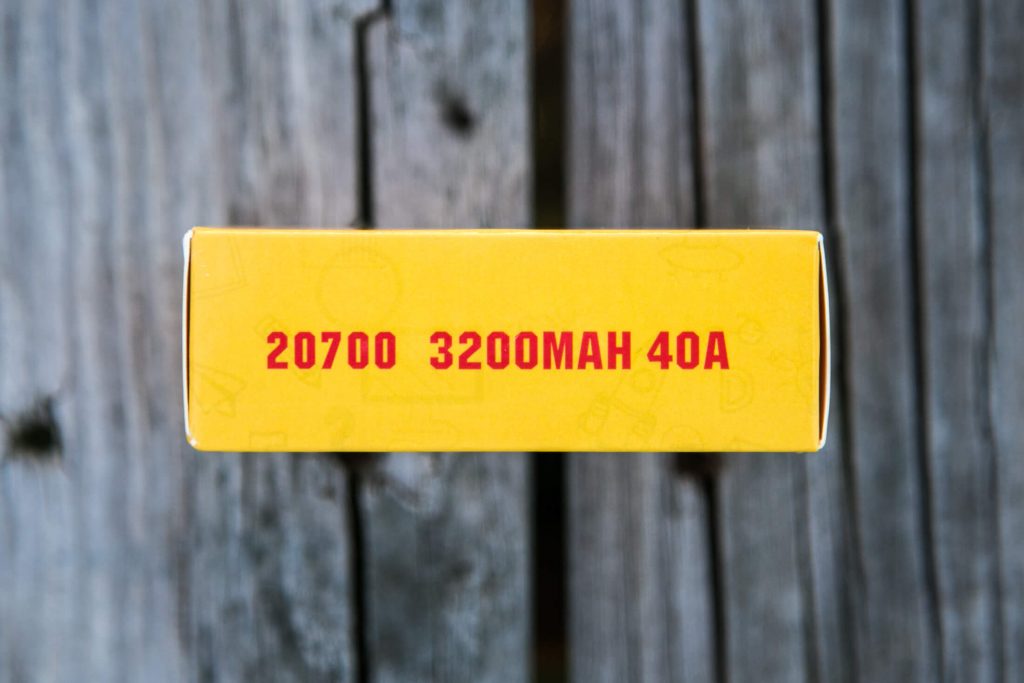 A yellow box displays red text reading 20700 3200MAH 40A against a wooden background.