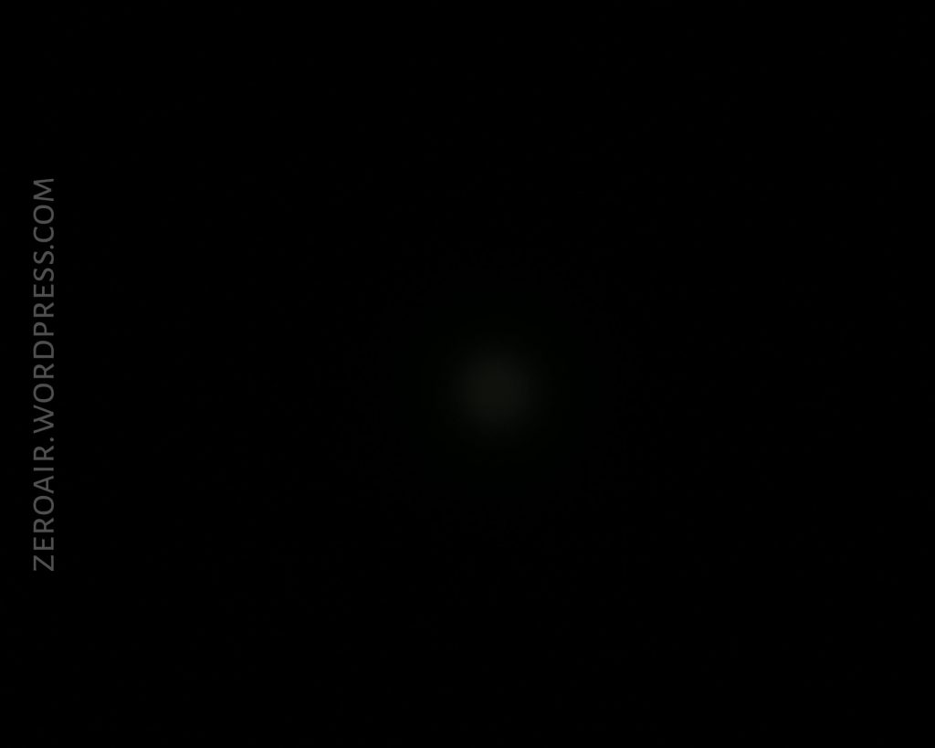 A mostly black image with a faint, blurry light spot in the center—likely from an Acebeam L16 Flashlight. The text ZEROAIR.WORDPRESS.COM appears vertically along the left side.