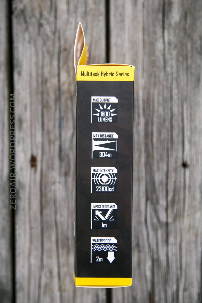 A black and yellow flashlight box shows specifications: 1800 lumens max output, 304m max distance, 23100 candela max intensity, 1m impact resistance, and 2m waterproof, with icons illustrating each feature.