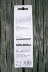 Back of an Olight S2R Baton II flashlight packaging on a wooden surface, showing a detailed product description, features, specifications, package contents, contact info, and regulatory icons.